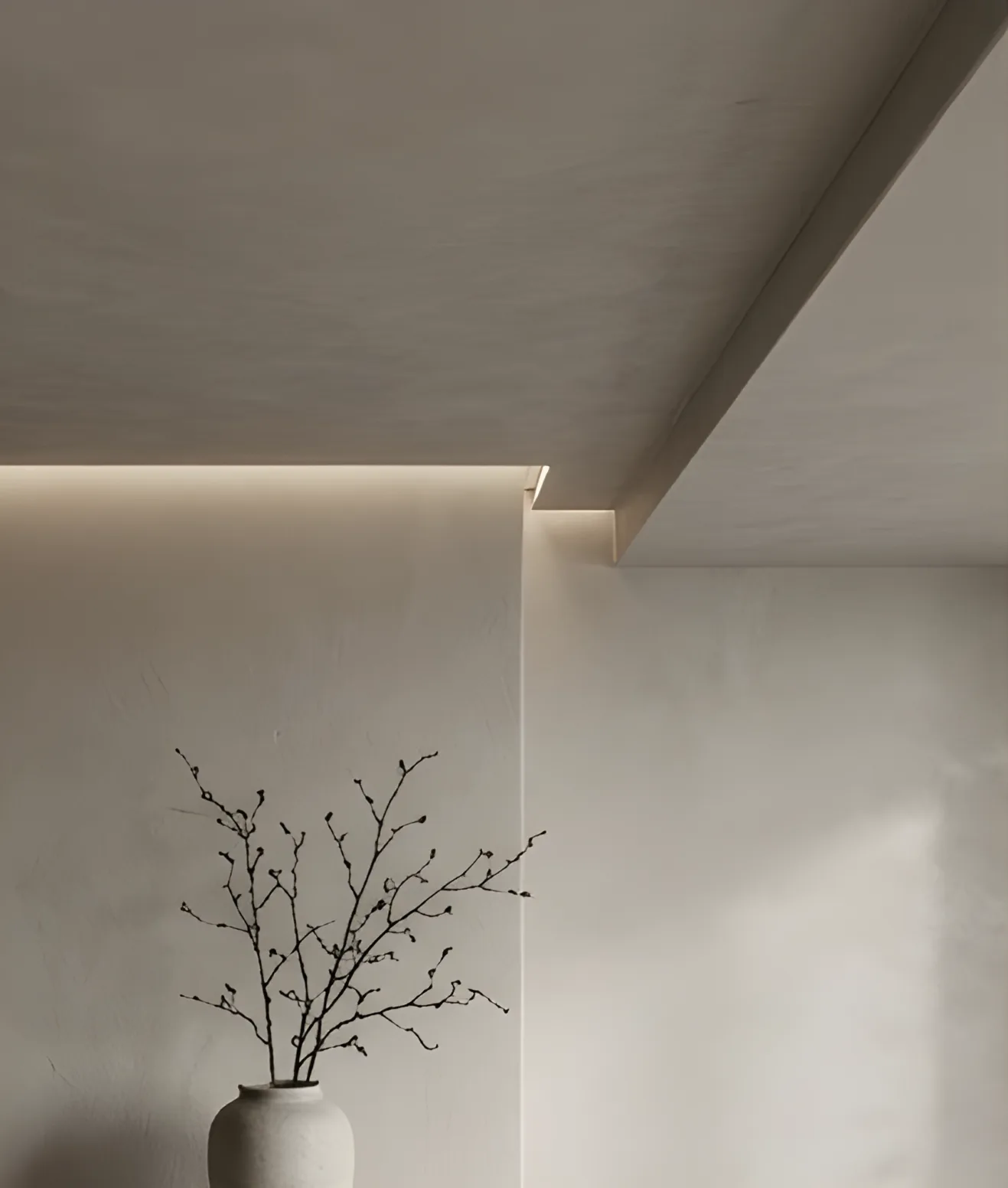 Elegante Mikrozement-Decke mit indirekter Beleuchtung und einer minimalistischen Vase im Vordergrund
