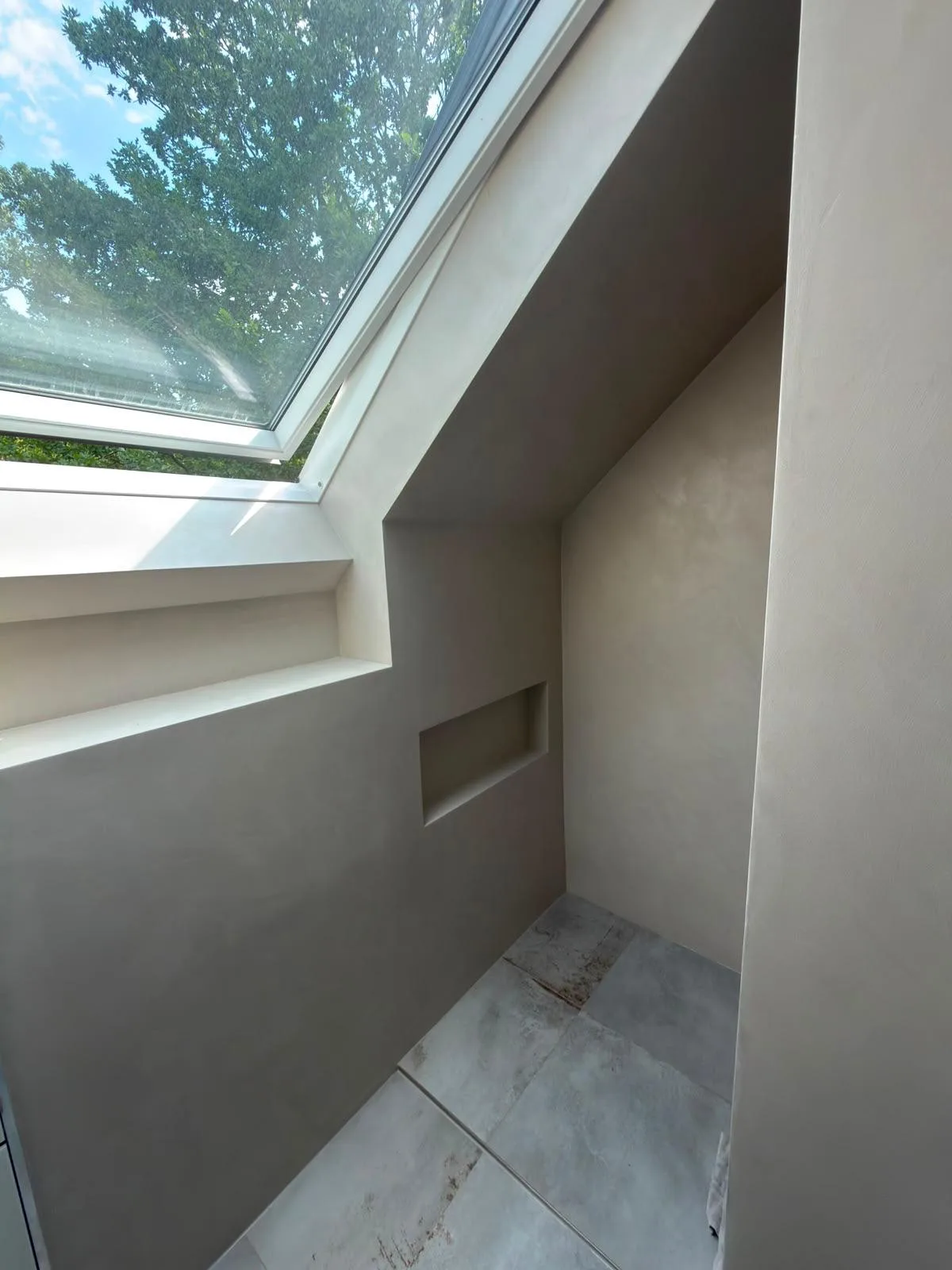Fugenlose Wandgestaltung mit Mikrozement in einem Badezimmer mit Fenster